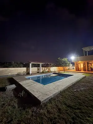 a swimming pool in front of a house at night at Casa de campo Rosenthal - Cieneguilla in Panquilma