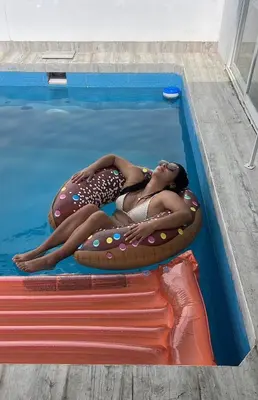a woman is laying on an inflatable at CASA CERCA a PLAYA NAPLO CON PISCINA in Pucusana