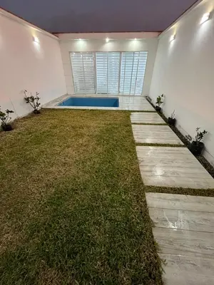 a backyard with a swimming pool and a grass yard at CASA CERCA a PLAYA NAPLO CON PISCINA in Pucusana
