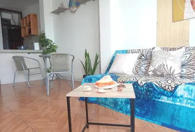 a living room with a blue couch and a table at Mini Depa km 43 Punta hermosa in Punta Hermosa