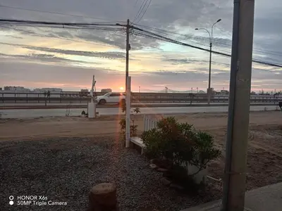 a car driving down a road with the sunset at Mini Depa km 43 Punta hermosa in Punta Hermosa