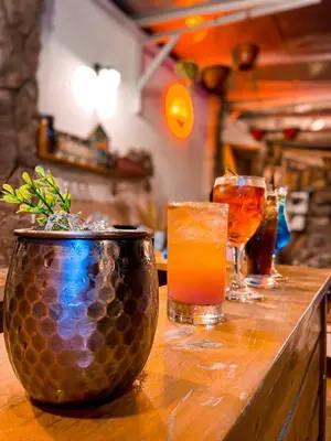 a table with two drinks and a vase on it at Las Delicias in Huacho