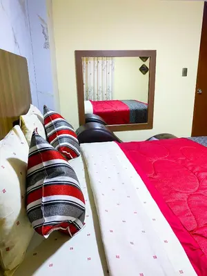 a bedroom with two beds with pillows and a mirror at Hostal Mayra Breña in Lima