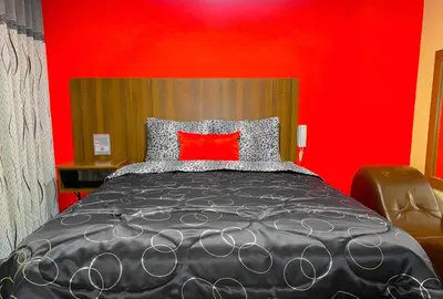 a bedroom with a bed with a red wall at Hostal Mayra Breña in Lima
