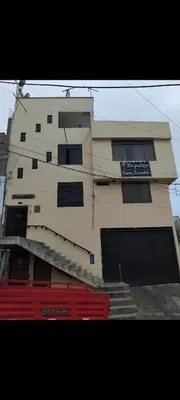 a tall building with a red fence in front of it at Hospedaje Puerto Escondido in Pucusana