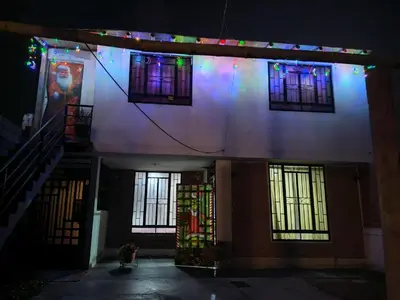 a building with stained glass windows and stairs at night at Casita de camucha segundo piso in Chincha Baja