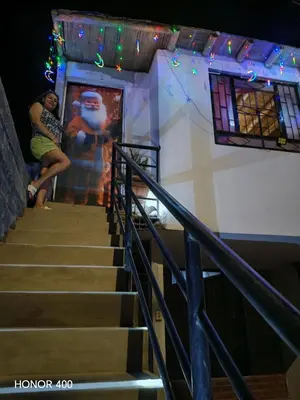a woman sitting on the stairs of a building at Casita de camucha segundo piso in Chincha Baja