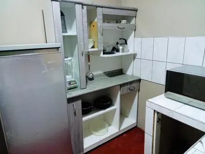 a kitchen with an open cabinet with dishes in it at Departamento habitación cama king in Lima