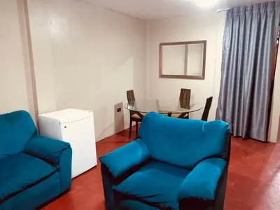 a living room with a blue couch and a table at Habitación cama queen in Lima