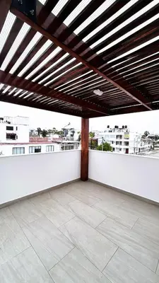 a patio with a white wall and a wooden ceiling at Beach house in Punta Hermosa, central beach area in Punta Hermosa