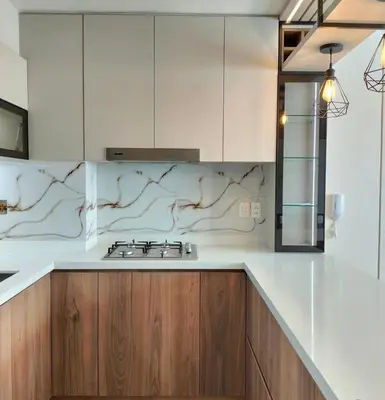 a kitchen with white counter tops and wooden cabinets at Apartamento amoblado in Lima