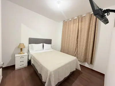 a bedroom with a bed and a television in it at Mary 2 in Paracas
