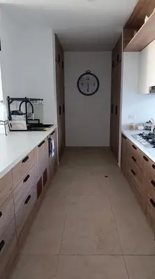 an empty kitchen with a clock on the wall at Casa de Playa a 15min del boulevard de Asia in Cerro Azul