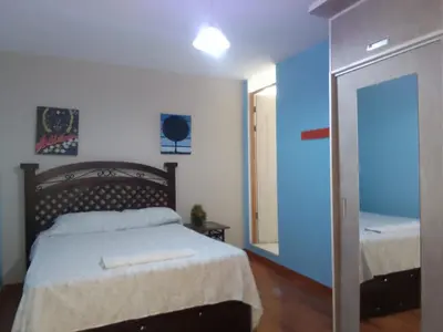 a bedroom with a bed and a mirror at Hospedaje Ocean Glips in Punta Negra