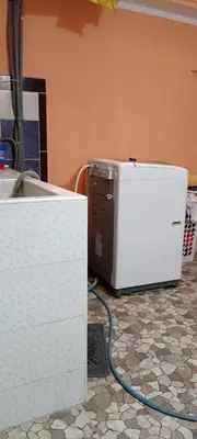 a microwave sitting on a kitchen floor with a hose at Casa del Olivar Pisco in Pisco