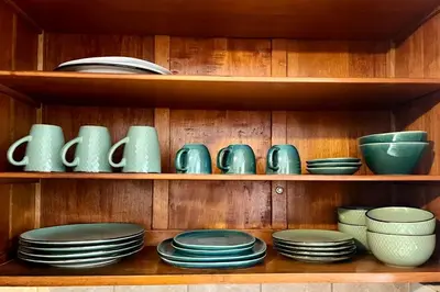 a wooden shelf with plates and bowls on it at Casa Cerezos in Ica