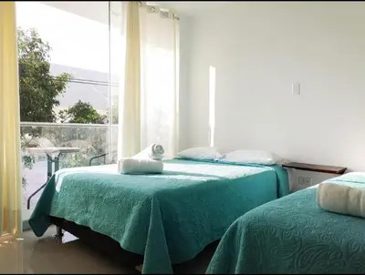 a bedroom with two beds and a large window at Hotel Inkayacu Paracas Café in Paracas
