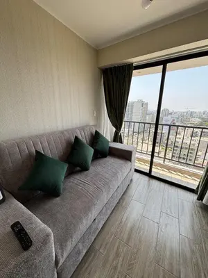 a living room with a couch and a large window at Modern apartment in Lima Surquillo in Lima