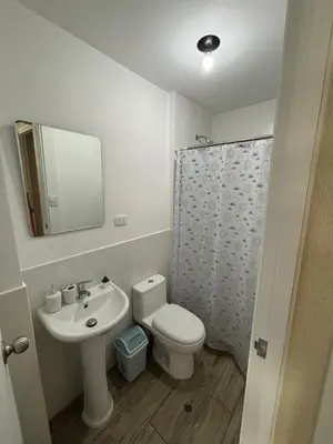 a bathroom with a sink and a toilet and a mirror at Modern apartment in Lima Surquillo in Lima