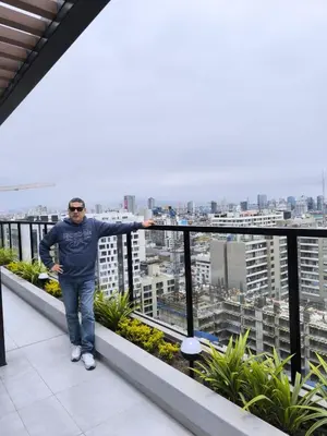a man standing on a balcony of a building at Confortable y moderno apartamento en Lima, cerca al centro de Lima, MIraflores y San IsidroN ISIDRO in Lima