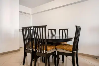 a dining room table with two chairs and a black table at Bajada Balta Suites Spacious 3BR in Miraflores Walkable Area in Lima