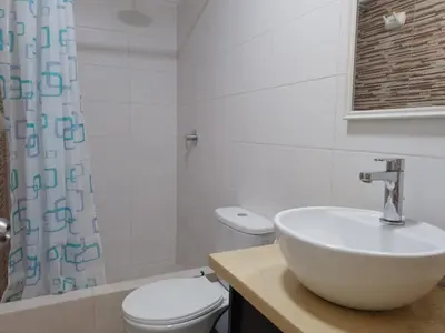 a white bathroom with a sink and a toilet at Cozy Central Apartment Ideal for Work & Travel in Lima