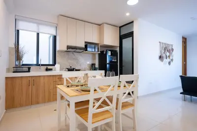 a kitchen and dining room with a table and chairs at Sol de Paracas Beach Homes by Vibrant in Pisco
