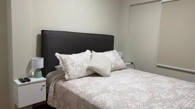 a bedroom with a bed with a black headboard and pillows at A2 cuadras de Larcomar - Miraflores in Lima