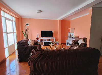 a living room with two couches and a tv at Wasin Kusi in Ayacucho