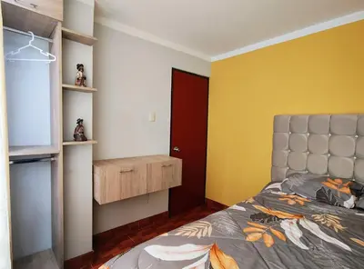 a bedroom with a bed and a red door at Wasin Kusi in Ayacucho