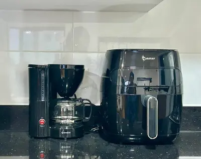 two black appliances sitting on a kitchen counter at Modern room by the sea in Lima