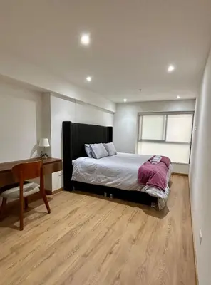a bedroom with a bed and a desk and a window at Modern room by the sea in Lima