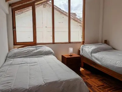 a bedroom with two beds and a window at UMAY lodge house in Urubamba
