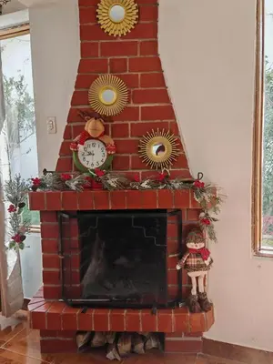 a red brick fireplace with a clock and christmas decorations at UMAY lodge house in Urubamba