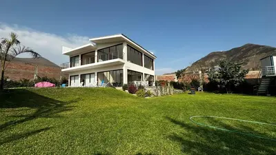a house on top of a grassy field at Welcome to our Pachacamac retreat in Pachacamac