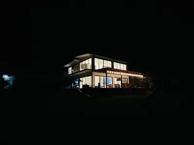 a large house with glass windows at night at Welcome to our Pachacamac retreat in Pachacamac