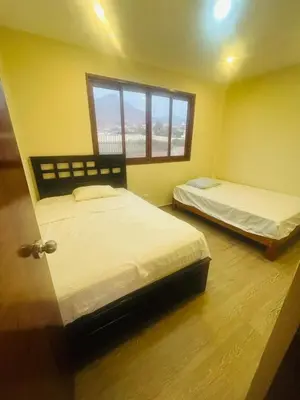 a room with two beds and a window at Welcome to our Pachacamac retreat in Pachacamac