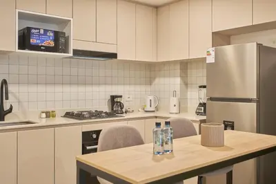 a kitchen with a table with chairs and a refrigerator at Saturn by Geko in Lima