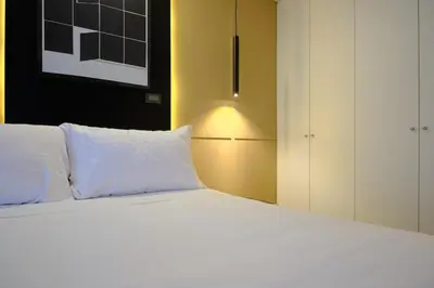 a bedroom with a white bed and a white cabinet at Saturn by Geko in Lima