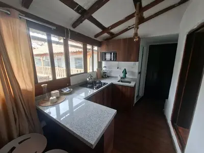a kitchen with a counter top and some windows at Acogedor Departamento Vitoque in Cusco