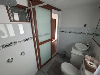 a bathroom with a shower and a toilet and a sink at Acogedor Departamento Vitoque in Cusco