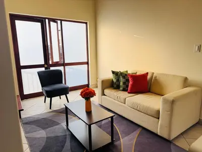 a living room with a couch and a chair at M25 Duplex a media cuadra Embajada de USA in Lima