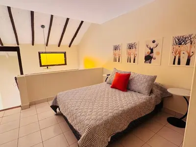 a bedroom with a bed with a red pillow at M25 Duplex a media cuadra Embajada de USA in Lima