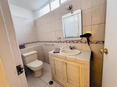 a bathroom with a toilet and a sink and a mirror at M25 Duplex a media cuadra Embajada de USA in Lima