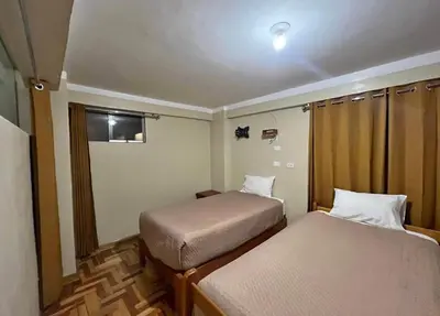 a small room with two beds and a window at Cozy aparts & rooms in Cusco