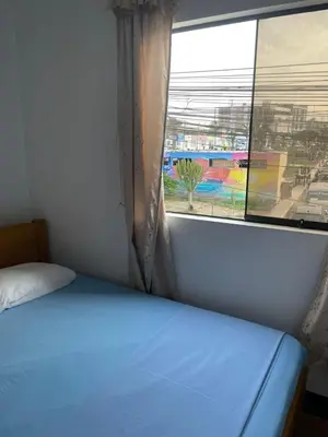 a bed in a room with a large window at HOSPEDAJE VISTA Del SOL PARACAS in Paracas