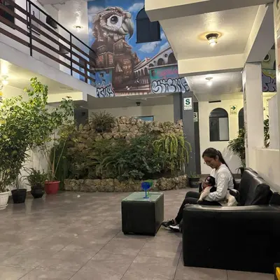a woman sitting on a couch in a lobby at Miraflores Thay Colonial in Lima