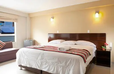 a bedroom with a large bed with white sheets and pillows at Mauri in Huánuco