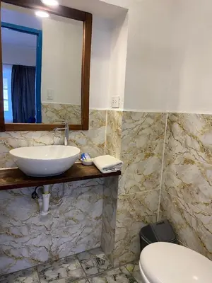 a bathroom with a sink and a toilet and a mirror at Runa House2 in Cusco
