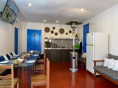 a kitchen and dining room with a table and a refrigerator at Runa House2 in Cusco